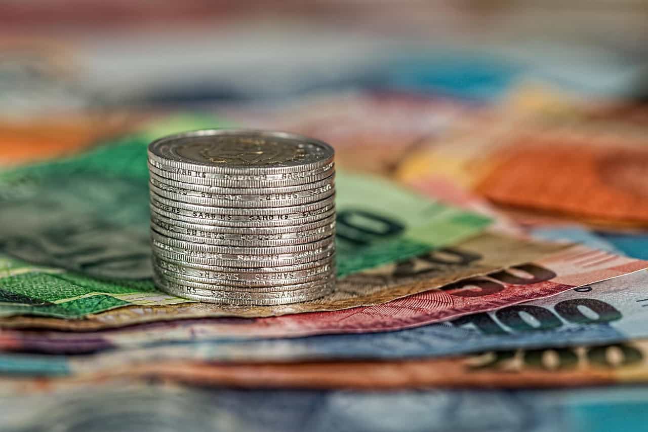 Stacked coins on Euro banknotes representing multi-currency business banking for non-residents