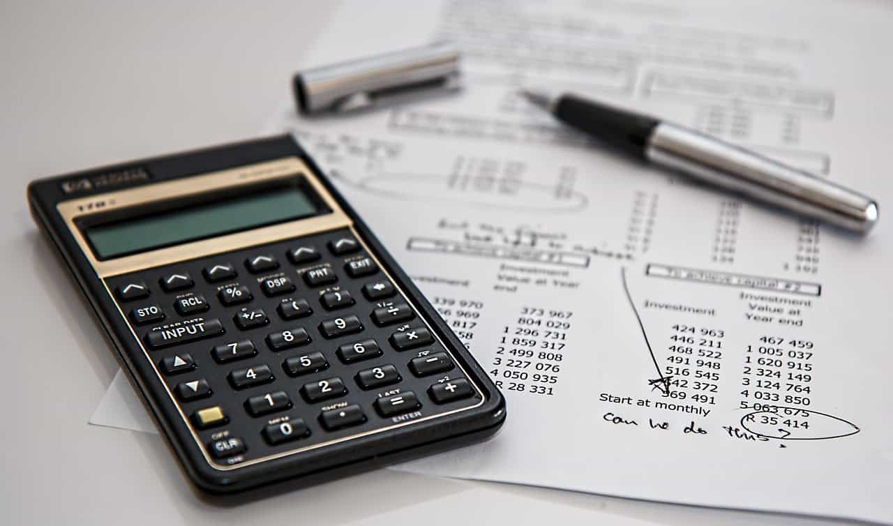 Calculator on financial ledger for corporate tax rate comparison across US LLC, Singapore Pte Ltd, and Dubai FZE