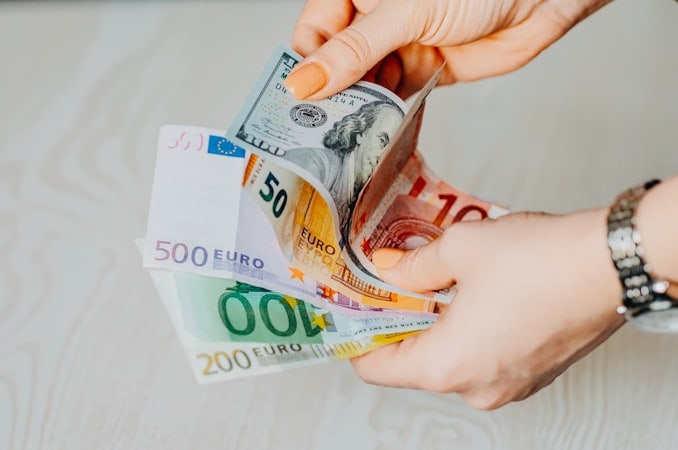 Entrepreneur counting cash managed across multiple currencies worldwide