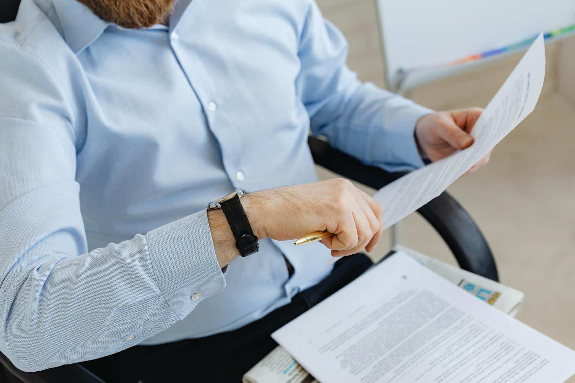 Businessman carefully reviewing corporate tax qualification papers and eligibility criteria