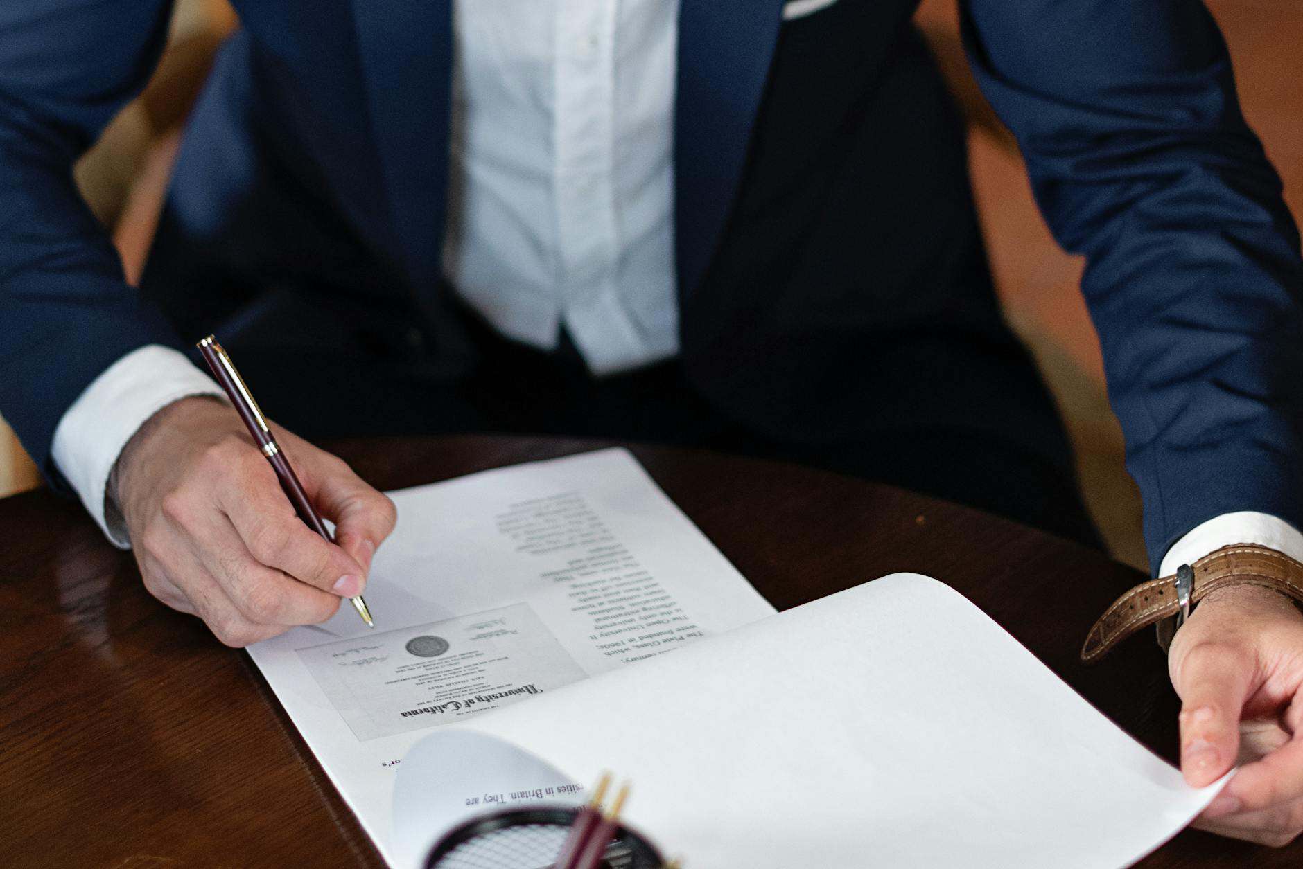 Business founder signing account opening documents at an office desk
