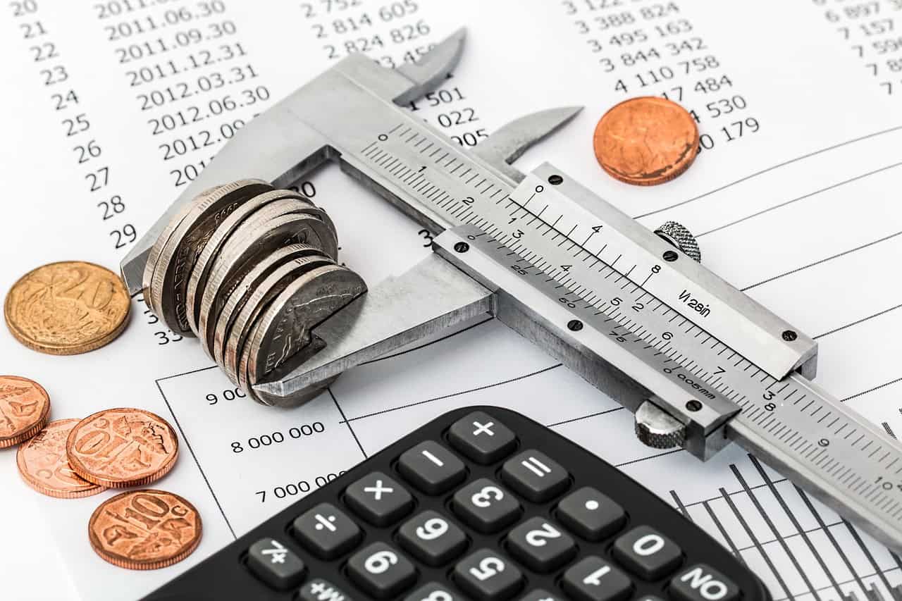 Calculator, coins, and financial documents on a desk for business cost planning