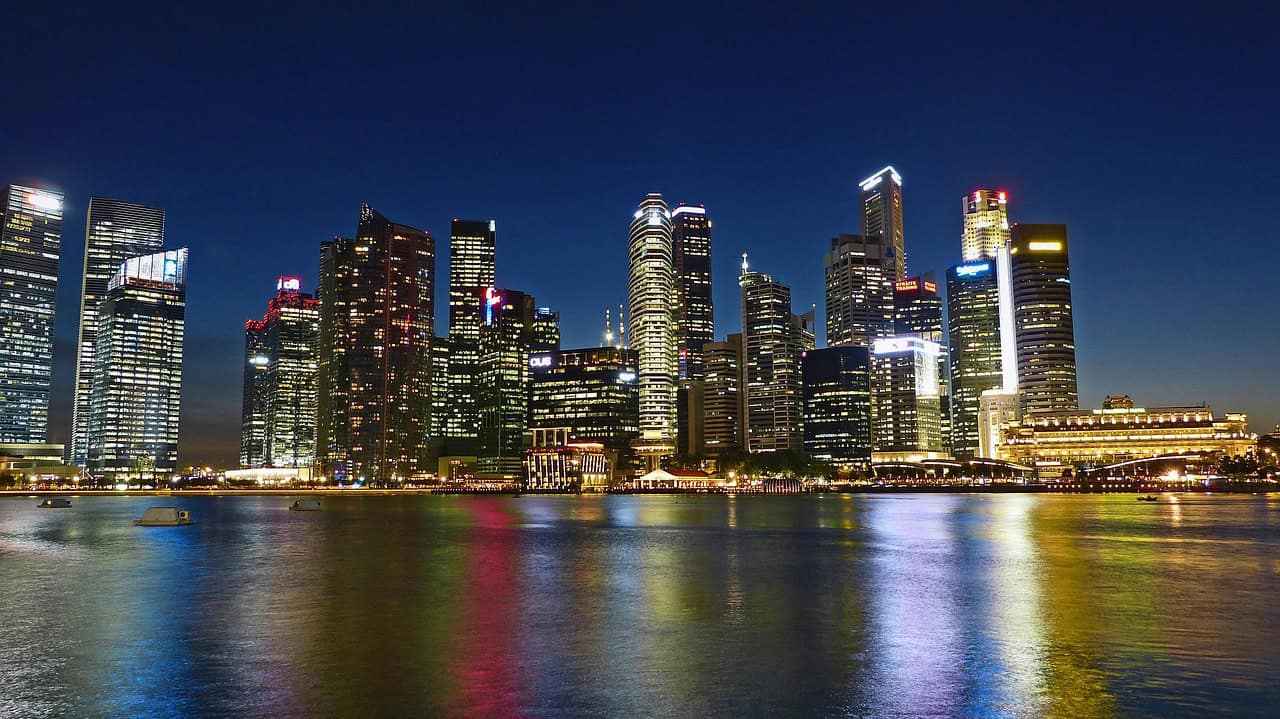 Singapore downtown skyline at night with illuminated skyscrapers reflecting on the water
