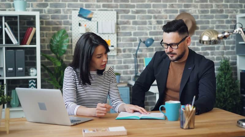 Colleagues high-fiving illustrate the fine line between contractor vs employee international status