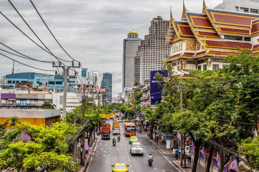 Busy Bangkok street with a temple and traffic, everyday life for expats in Thailand
