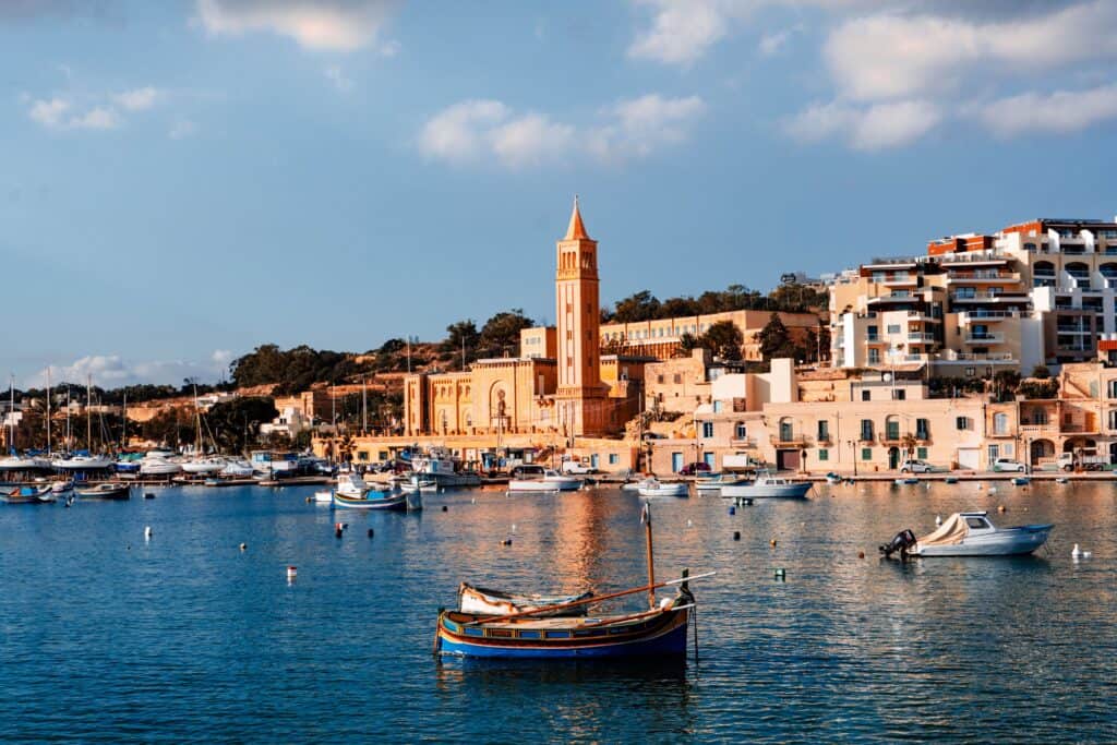 Marsaxlokk harbour in Malta with traditional fishing boats and waterfront buildings