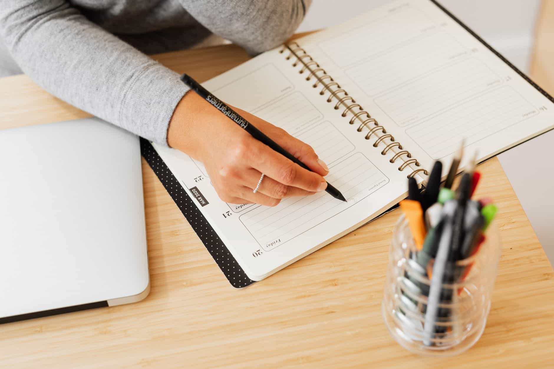 Hand writing in a planner to map out a 90-day action plan for thailand for digital nomads