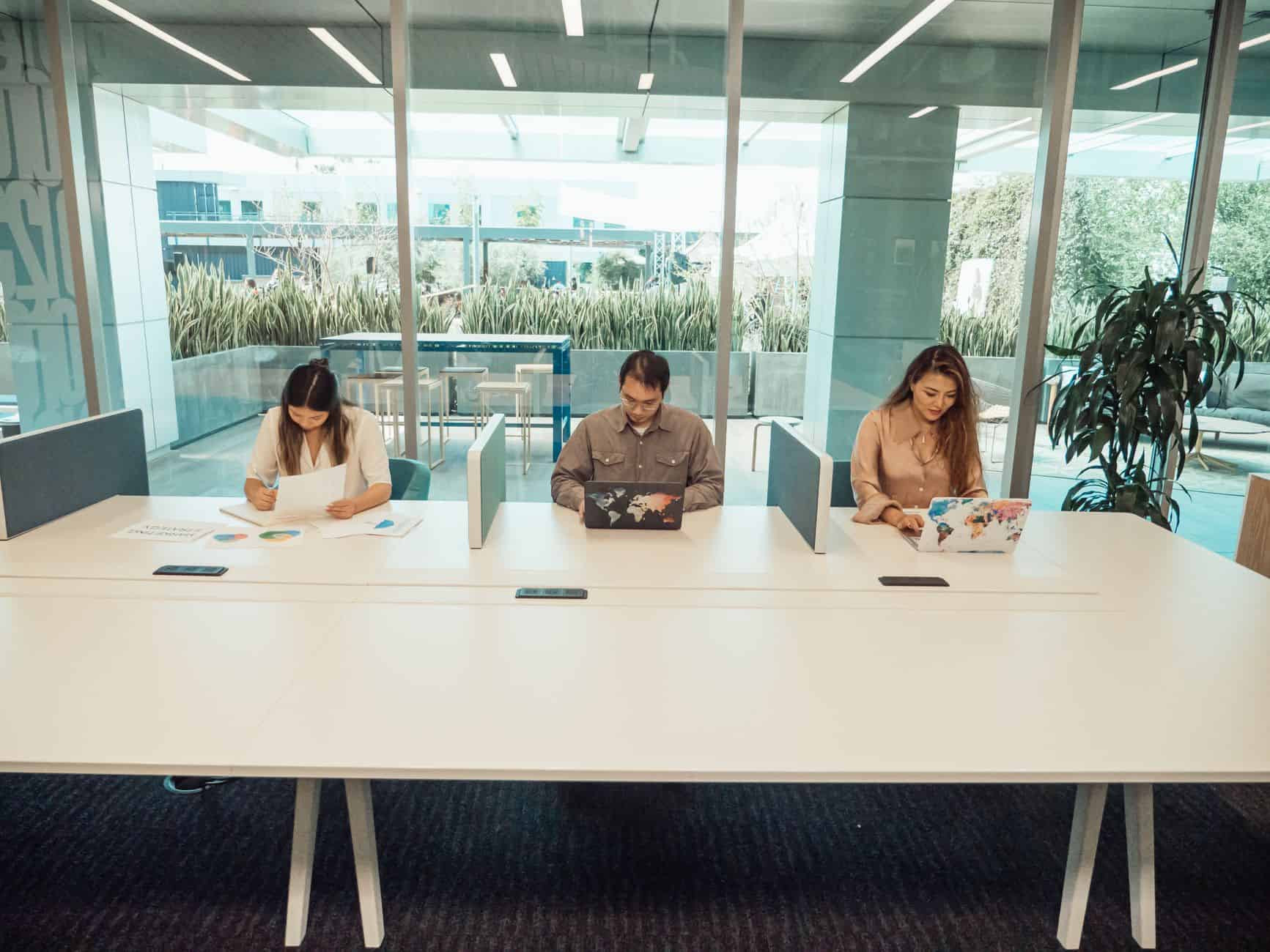 Three professionals defining international compensation for remote teams in a collaborative setting