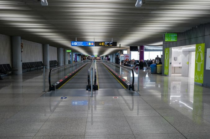 Airport terminal escalator representing international travel and tax residency compliance for global entrepreneurs