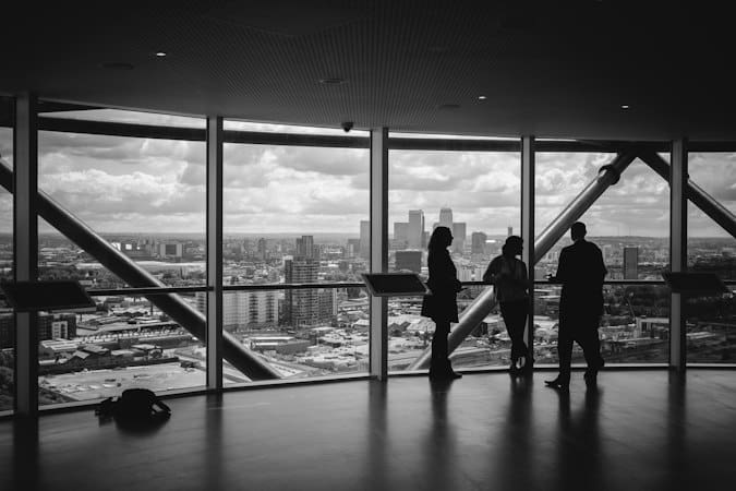 Team meeting near glass wall discussing governance controls for remote work tax compliance