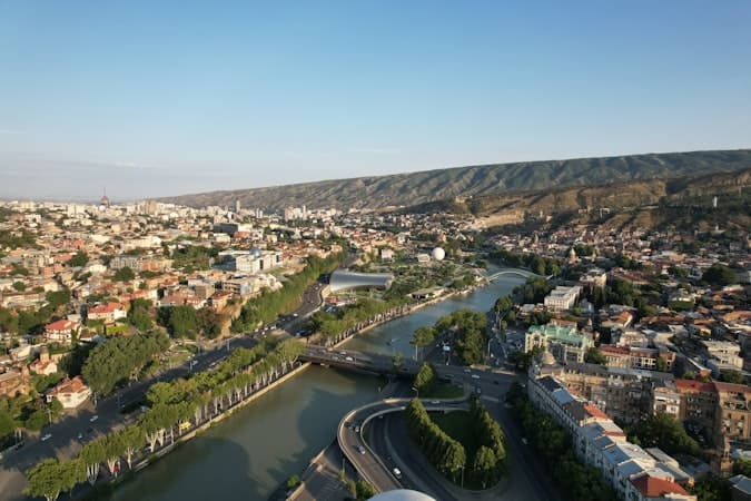 Aerial panorama of Tbilisi river city where employment law shapes entrepreneur hiring decisions