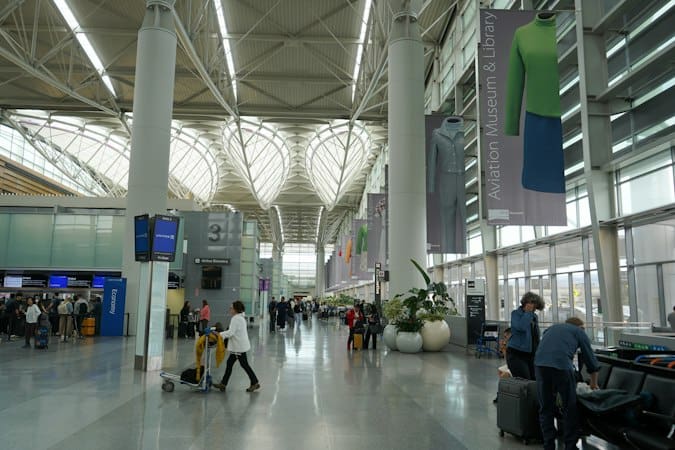 Travelers at airport check-in representing international mobility and certificate costs